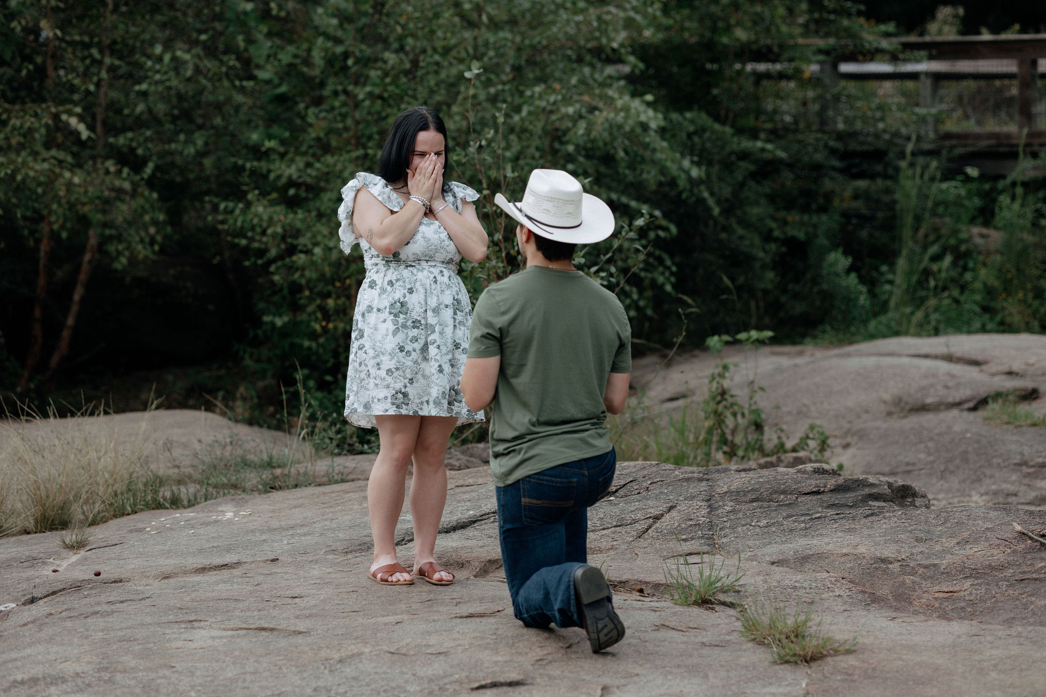 A boyfriend gets down on one knee to ask his girlfriend to marry him during their proposal at the Saluda Riverwalk in Columbia, South Carolina.