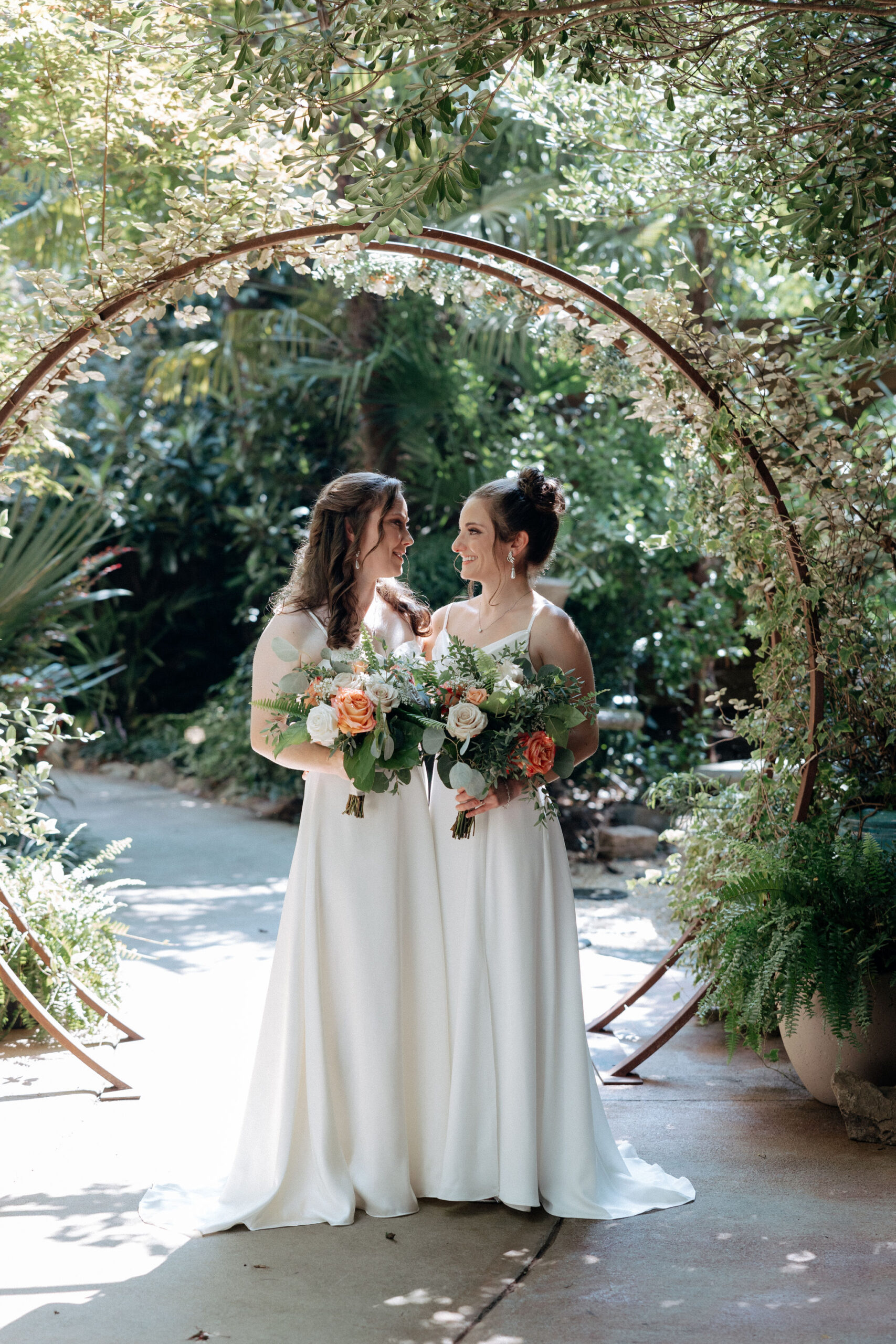 Brides gaze at each other in the gardens at River Road and Jasmine House in Columbia, South Carolina.