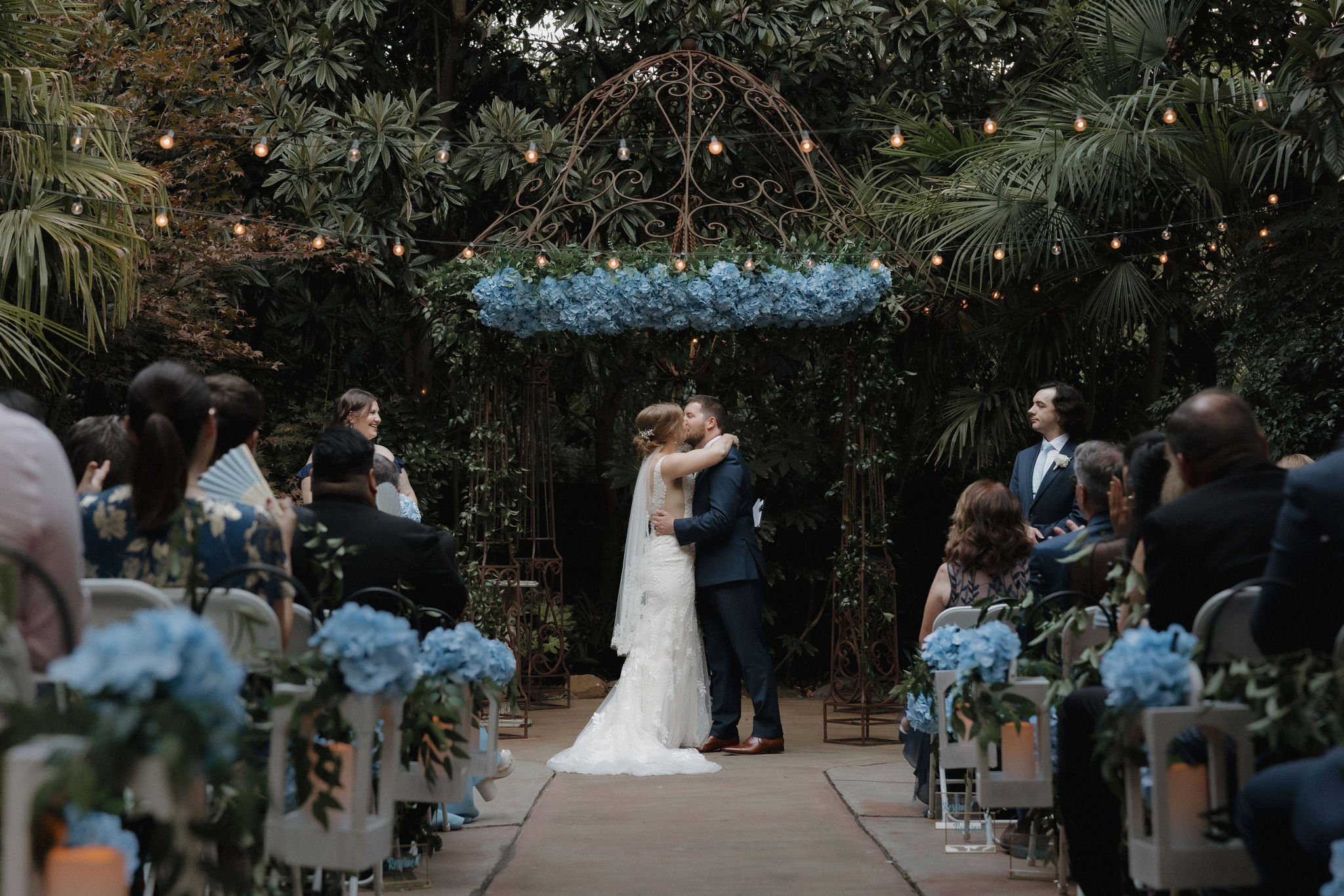 A bride and groom share a first kiss during their wedding ceremony at River Road & Jasmine House & Gardens in Columbia, South Carolina.