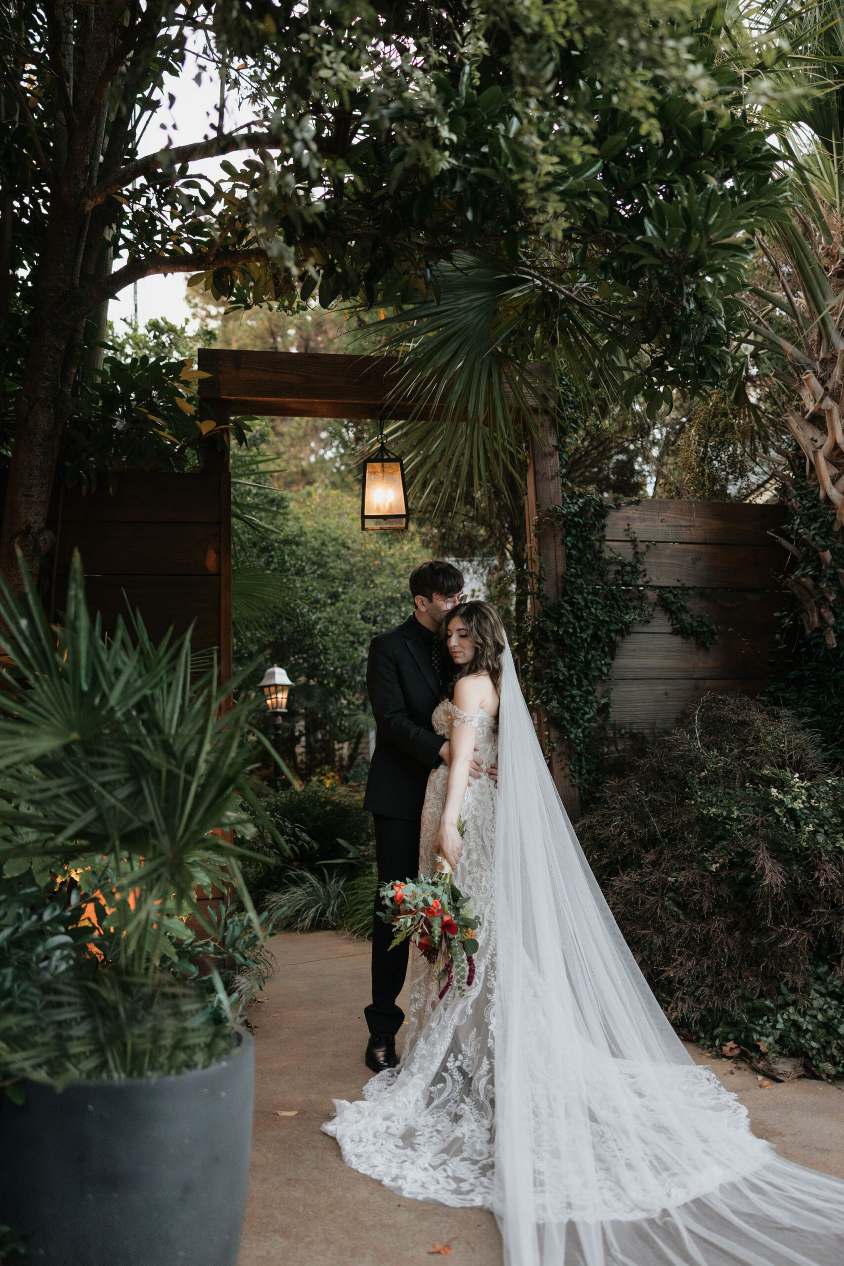 A bride and groom pose for a portrait in front of the entrance to the River Road and Jasmine House in Columbia, SC.