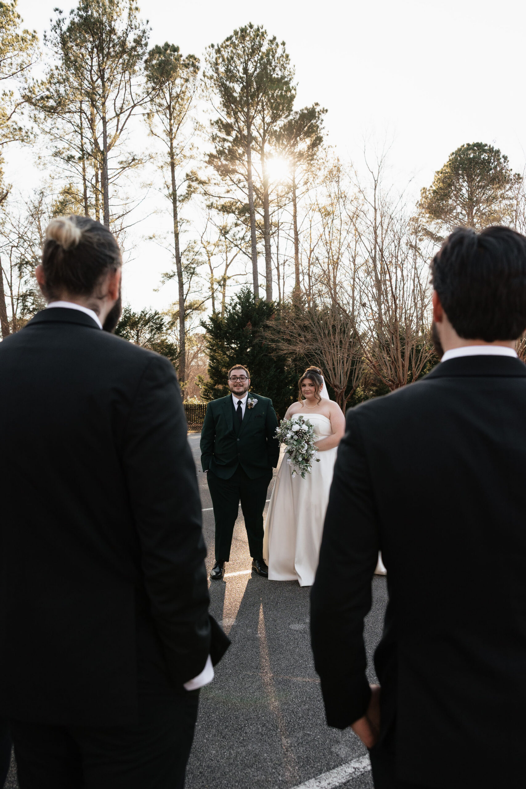 A bride and groom is talking to the best man and a groomsman on their wedding day.