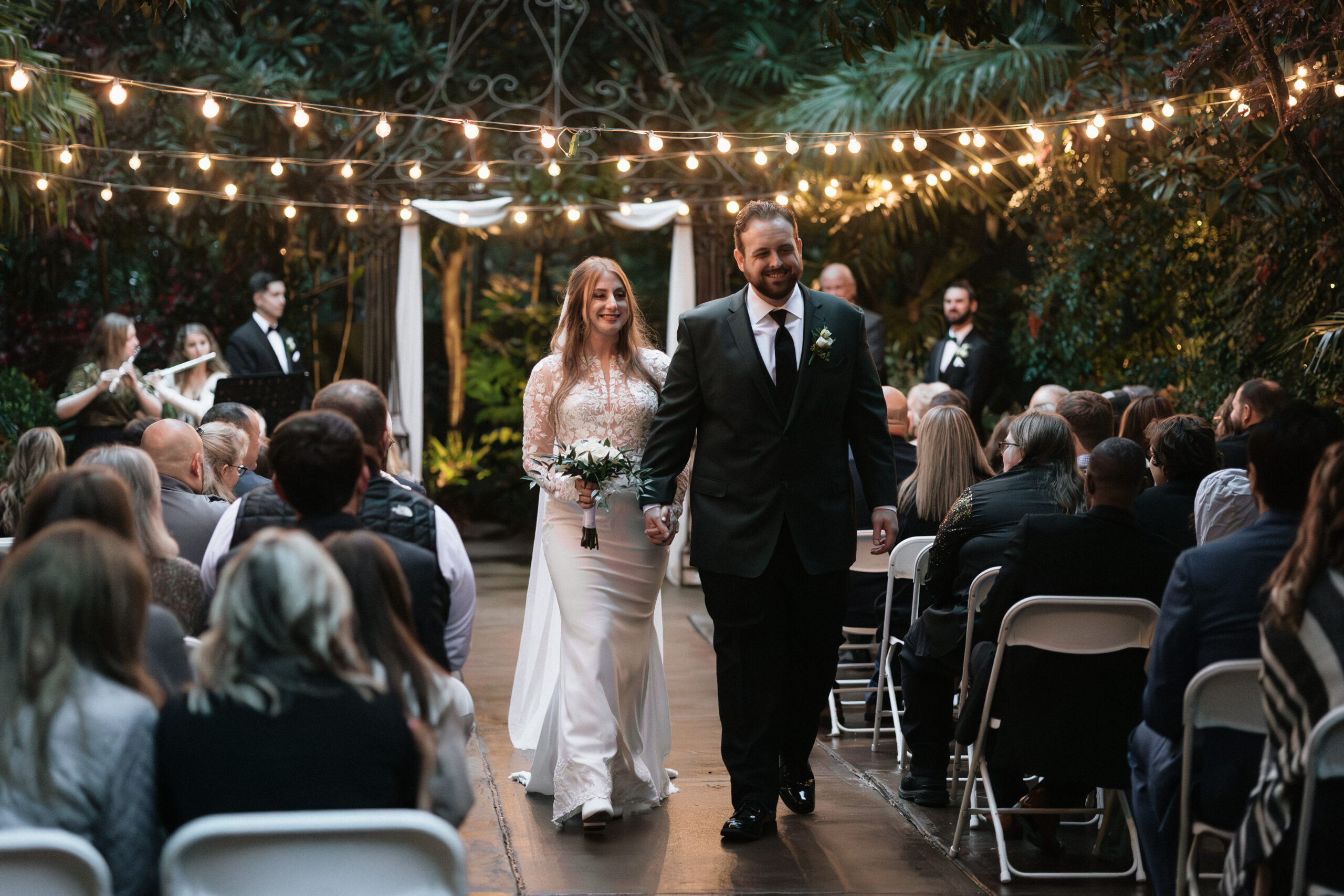A couple walks back down the aisle after the conclusion of their winter wedding ceremony at the River Road and Jasmine House.