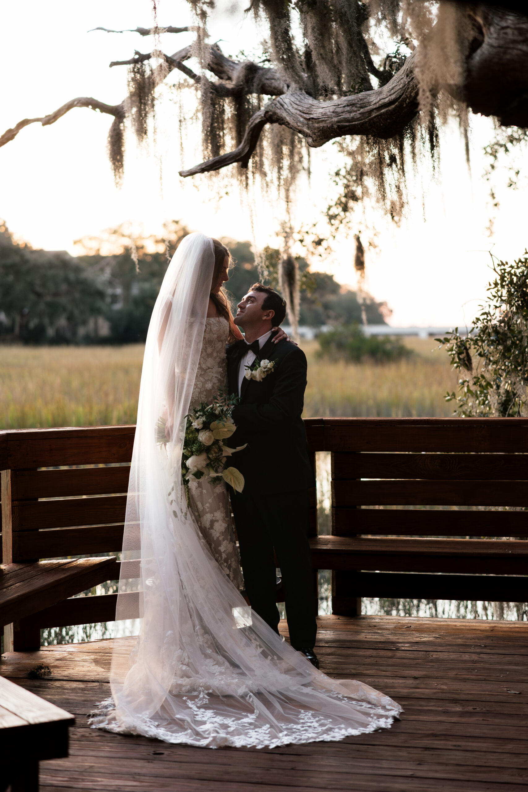 A couple takes an editorial photo during golden hour on a boardwalk in Hilton Head, South Carolina.